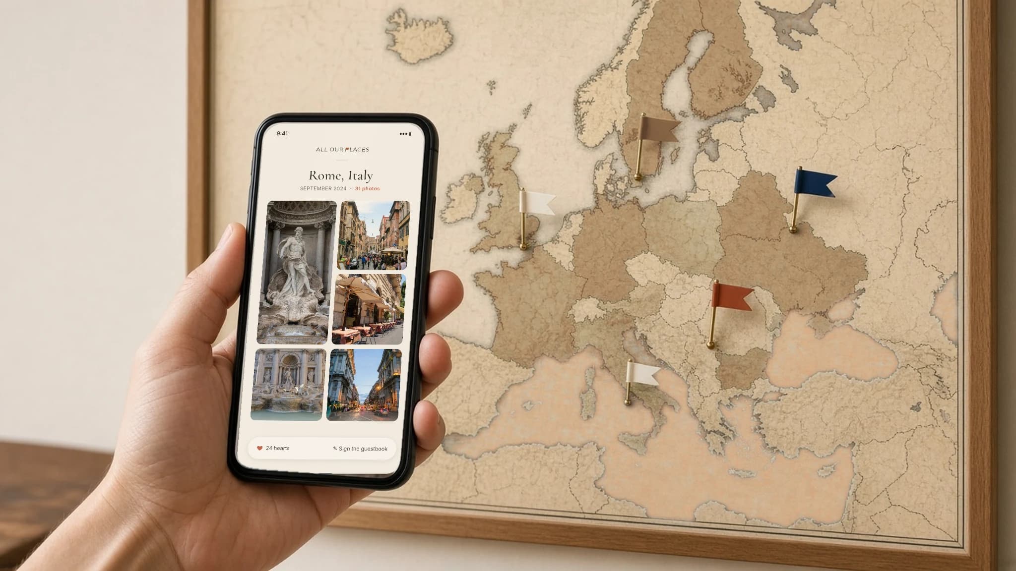 Phone open to the Amalfi Coast gallery beside a framed Saddle-style map of Europe